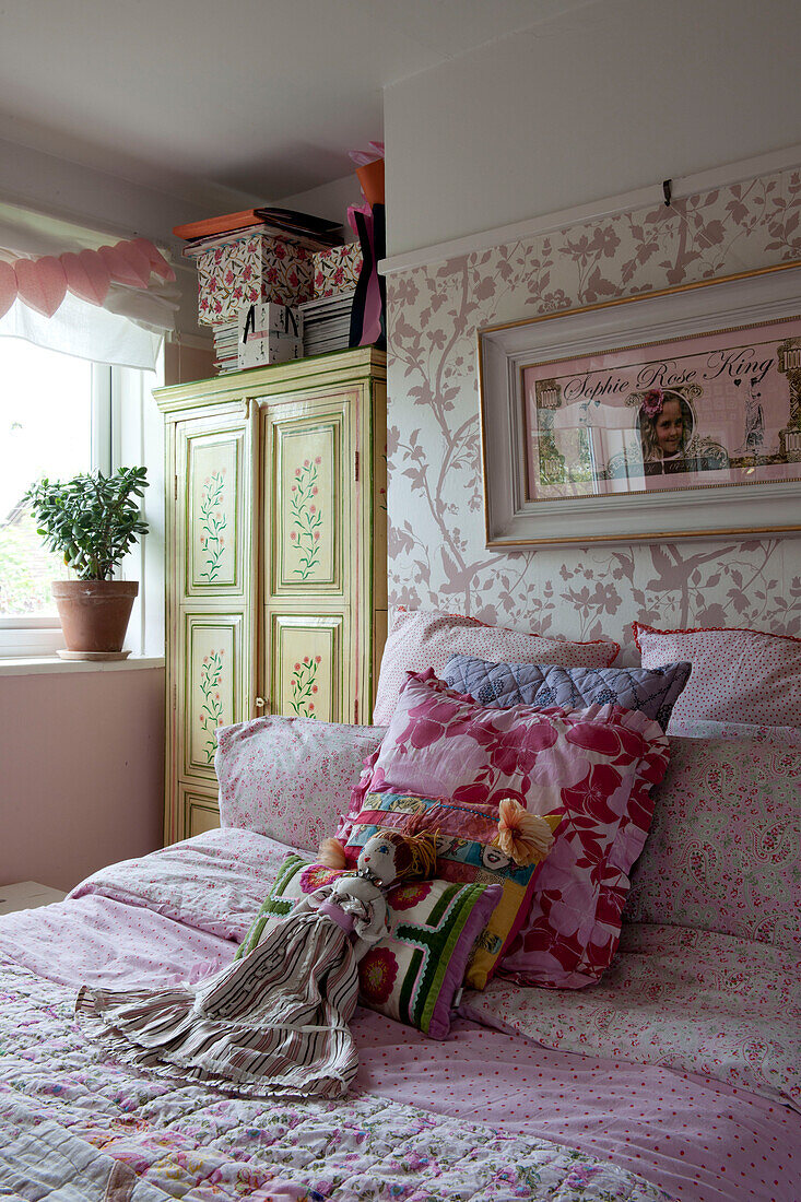 Rag doll on bed in girls' room,  contemporary Lewes home,  East Sussex,  England,  UK