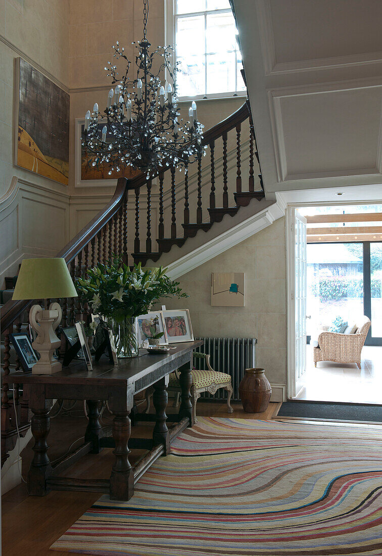 Patterned rug in hallway of Tiverton country house with chandelier,  Devon,  England,  UK