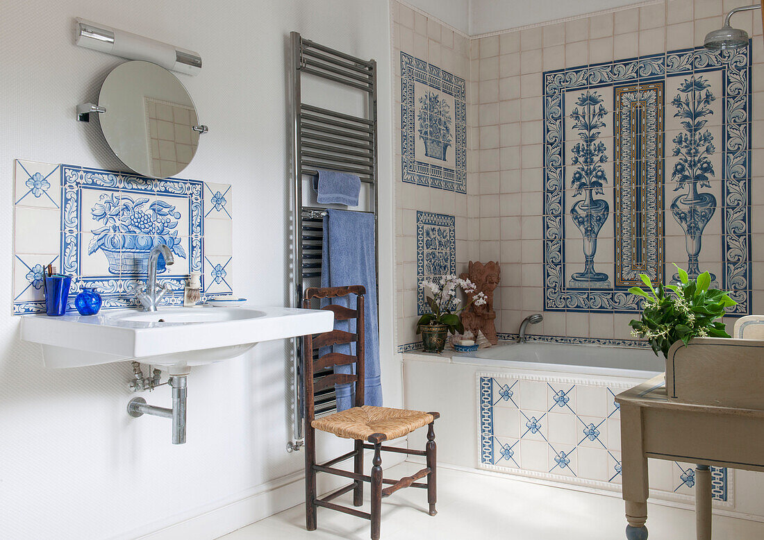 Blue bath towel and chair in tiled bathroom of London home  England  UK