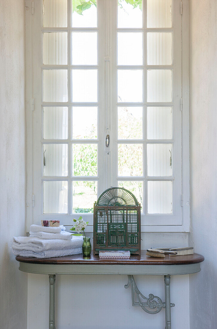 Vintage birdcage with folded towels at window of Dordogne residence  Perigueux  France