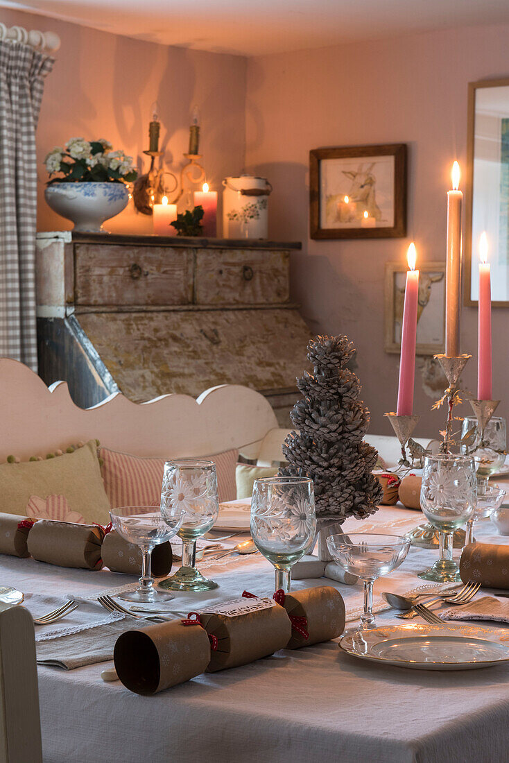 Vintage-Gläser und brennende Kerzen auf dem Esstisch zu Weihnachten in einem unter Denkmalschutz stehenden Haus (Grade II) in Kent