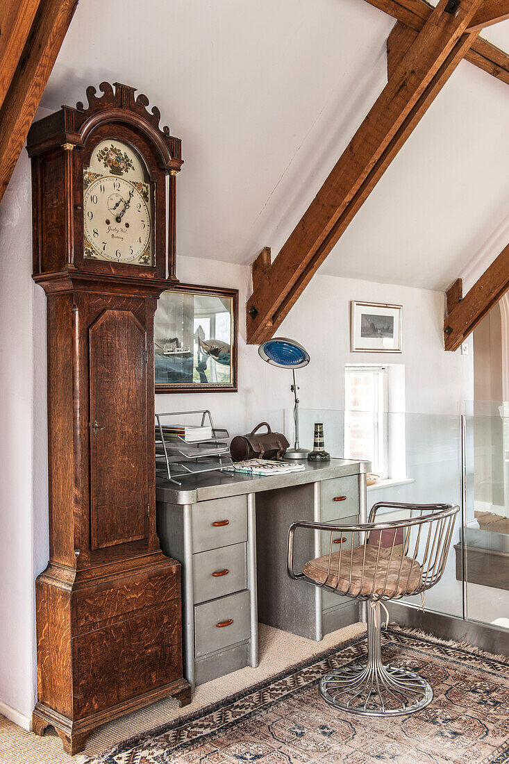 Vintage metal desk and chair with grandfather clock on landing study in Norfolk coastguards cottage  England  UK