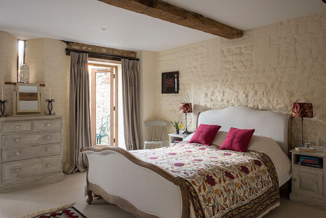 Embroidered quilt on double bed in 18th century Norfolk barn conversion  England  UK