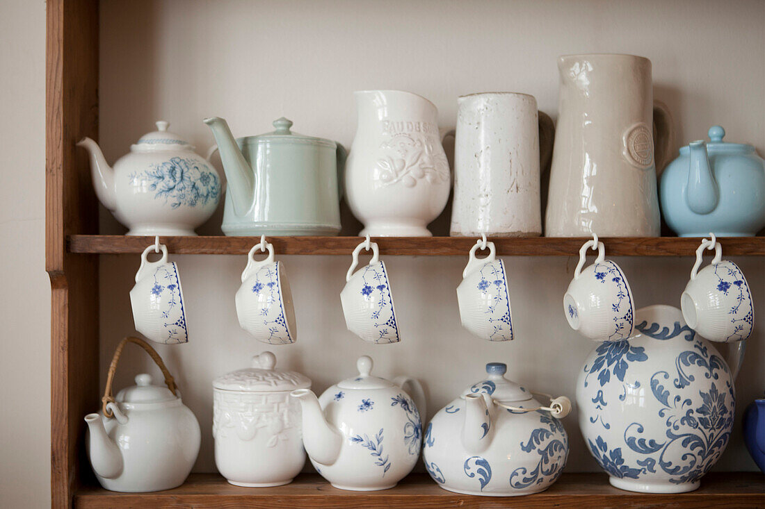 Sammlung von Teetassen und Teekannen auf einer Holzkommode in einem Haus in Brighton, East Sussex, England, UK