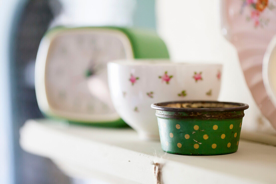 Vintage pot and teacup with clock on shelf in Amberley kitchen West Sussex UK