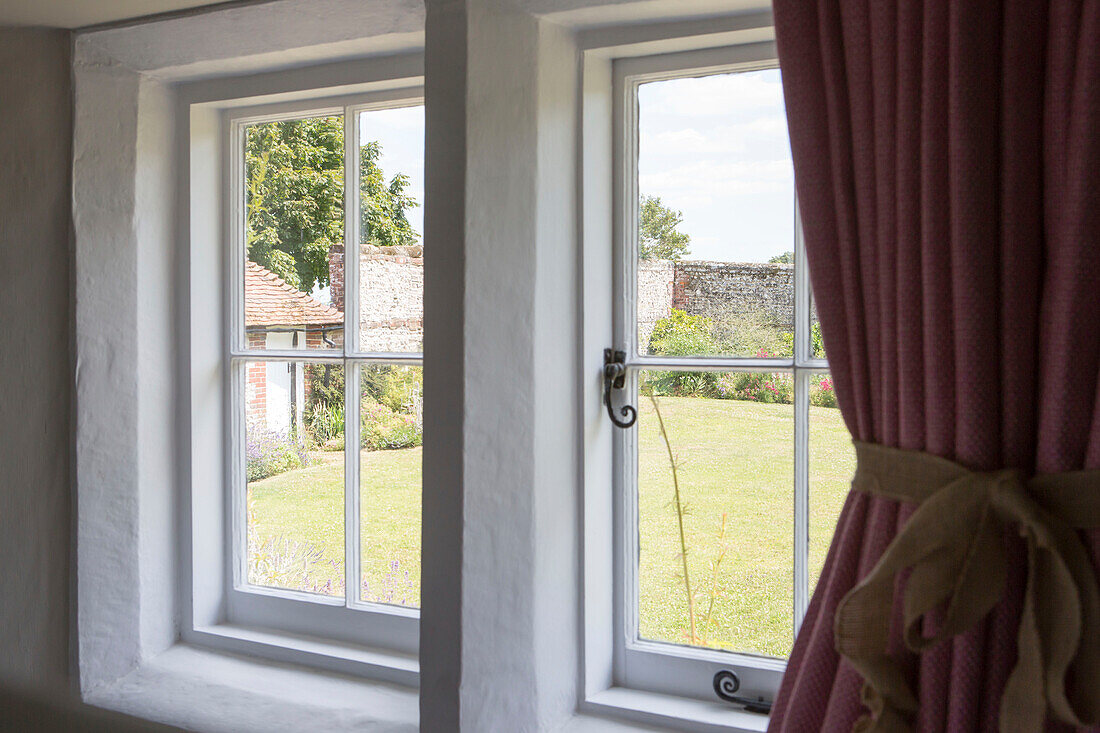 View to garden through whitewashed windows of Petworth farmhouse West Sussex Kent