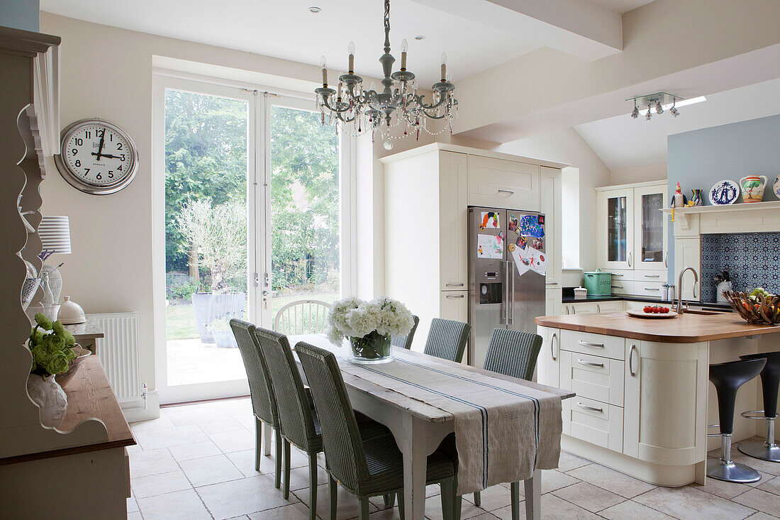 Dining table with wicker chairs in open plan kitchen of Amberley family home West Sussex England UK