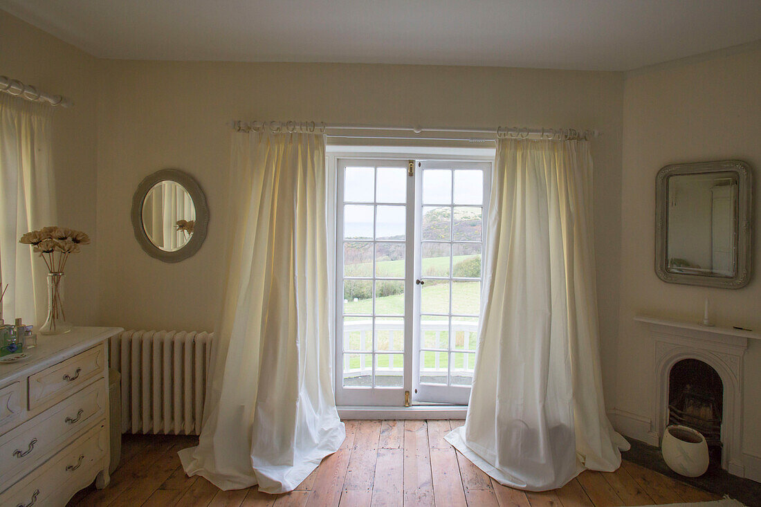 Durchgehende cremefarbene Vorhänge an französischen Fenstern mit Blick auf das Meer im Pfarrhaus aus dem 16