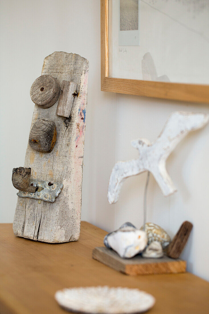 Muscheln, Treibholz und eine Modellmöwe auf einer Holzkonsole in einem Haus in West Wittering, West Sussex, England