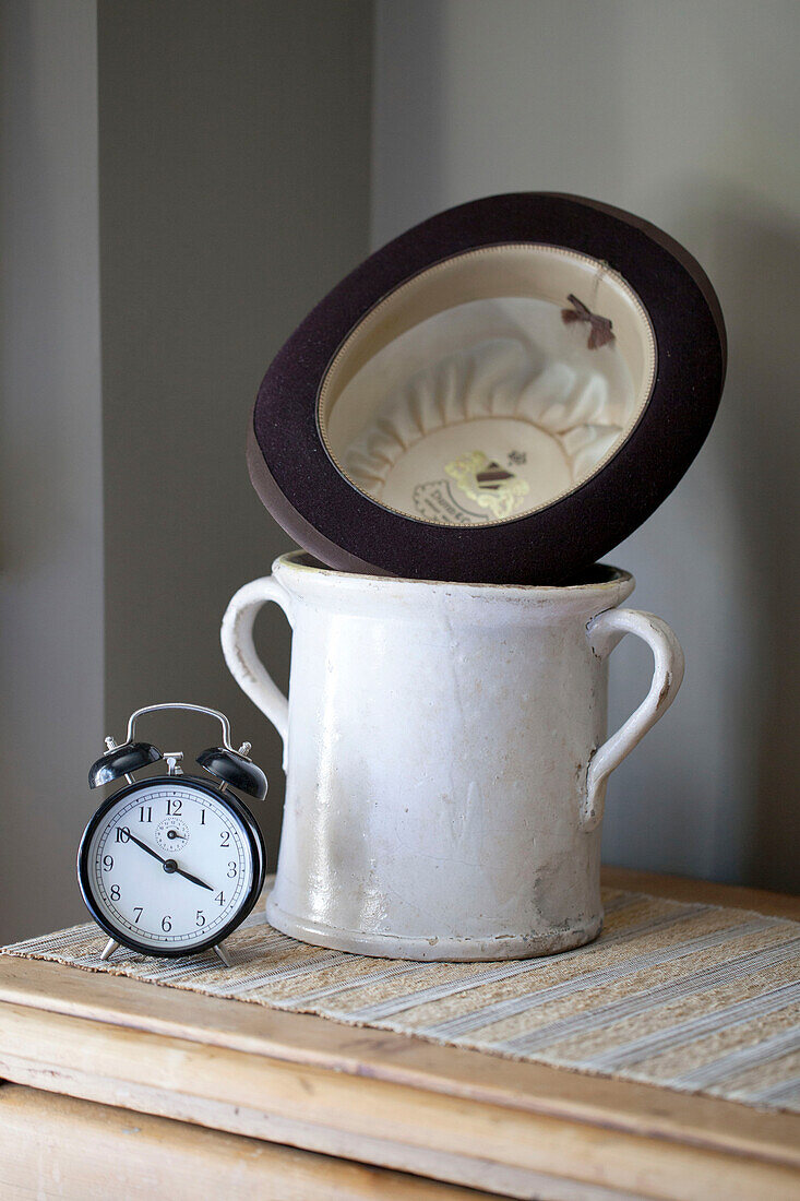 Bowler-Hut und Vintage-Glas mit Wecker in edwardianischem Stadthaus in West Sussex England UK