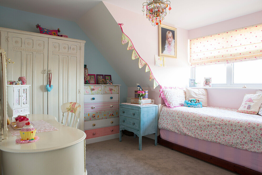Girl's room with spotted blinds floral duvet and upcycled chest in 1950s West Sussex family home UK