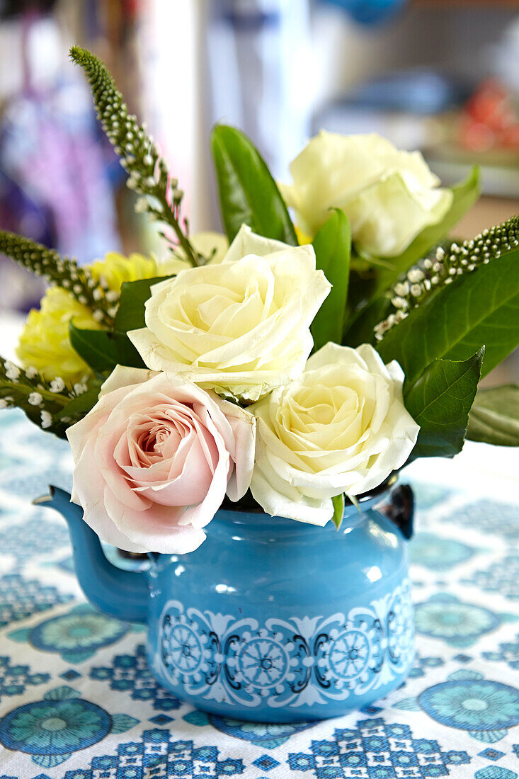 Cut roses in retro teapot in Brabourne farmhouse kitchen,  Kent,  UK