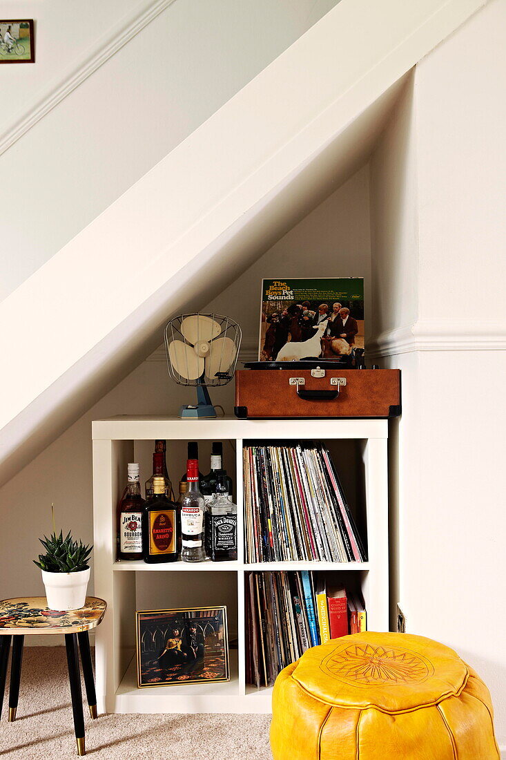 Vintage record player and bookcase under stairs in Birmingham home  England  UK