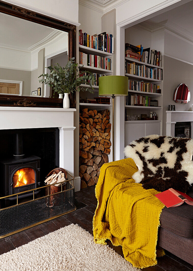 Pelzdecke auf dem Sofa vor dem Kamin im Wohnzimmer einer modernen Londoner Wohnung England UK