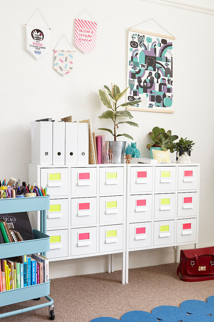 Houseplants on filing cabinet with stationery trolley in Alloa home  Scotland  UK