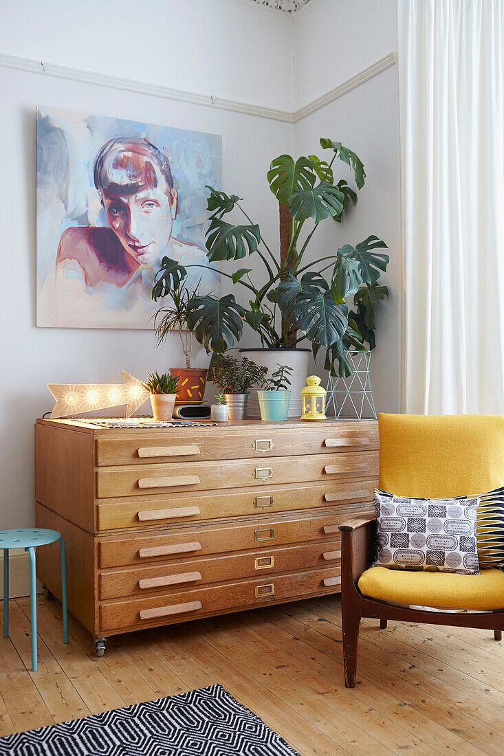 Gelber Sessel mit Zimmerpflanze auf Sideboard im Wohnzimmer eines Hauses in Alloa, Schottland UK