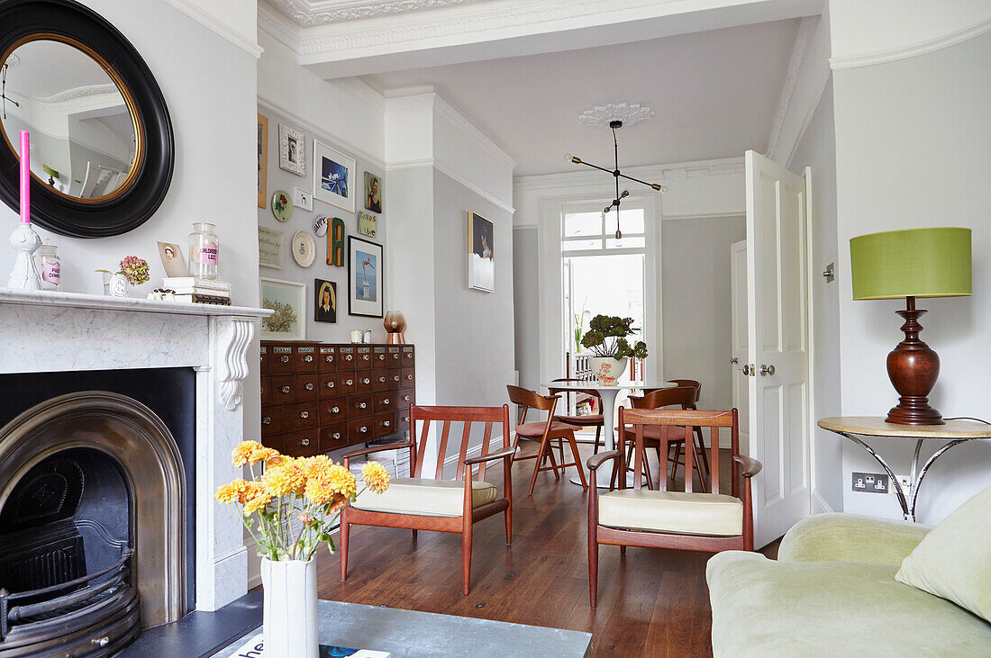 Pair of wooden armchairs in double living room of London home  UK