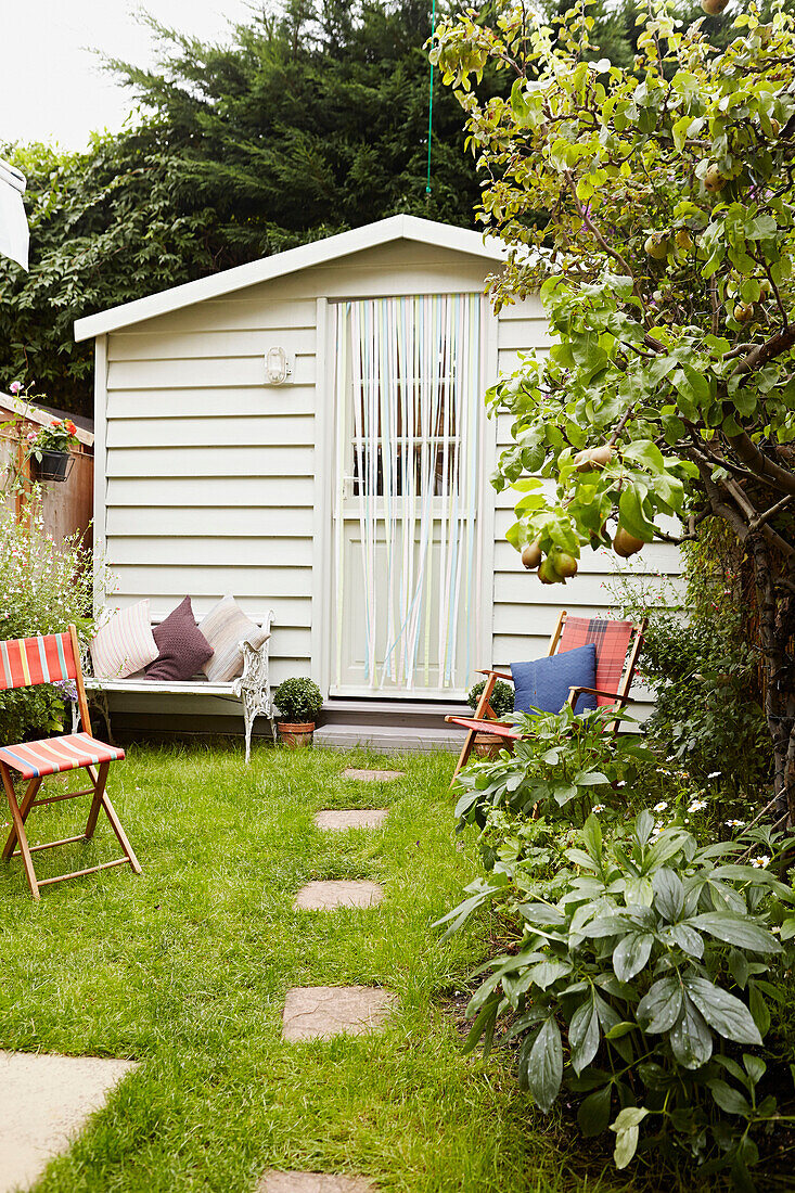 Liegestühle vor dem Gartenhaus im Hintergarten eines Hauses in Faversham, Kent, Großbritannien