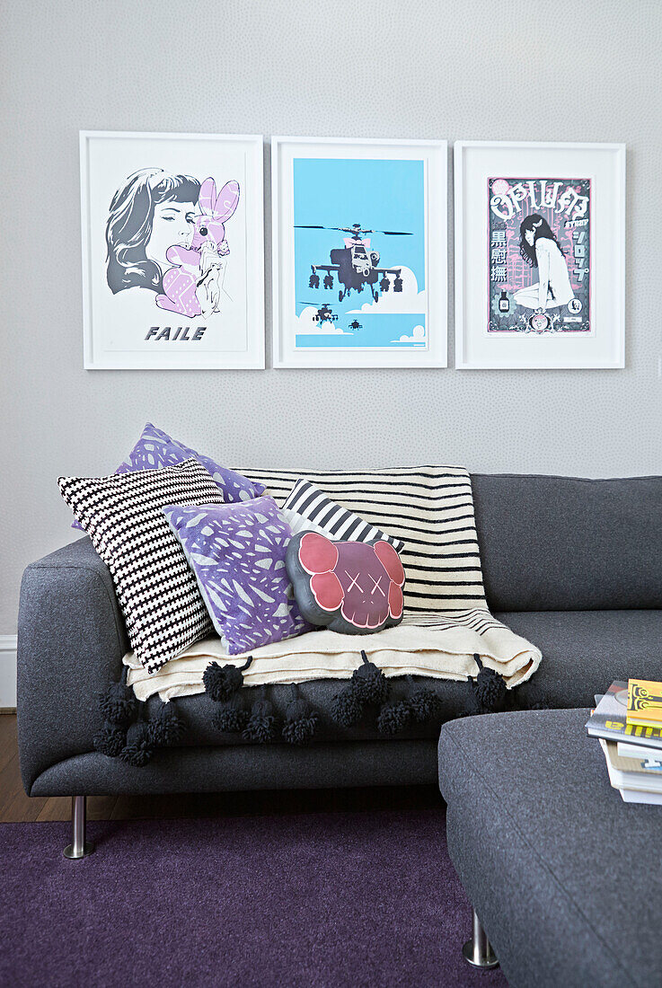 Gerahmte Drucke über Sofa mit Kissen im Wohnzimmer eines Londoner Stadthauses England UK