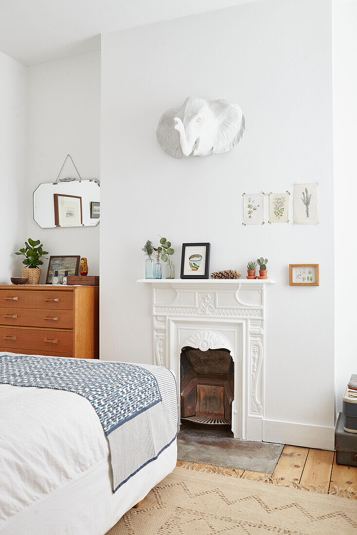 Mirror above painted fireplace in London bedroom  UK