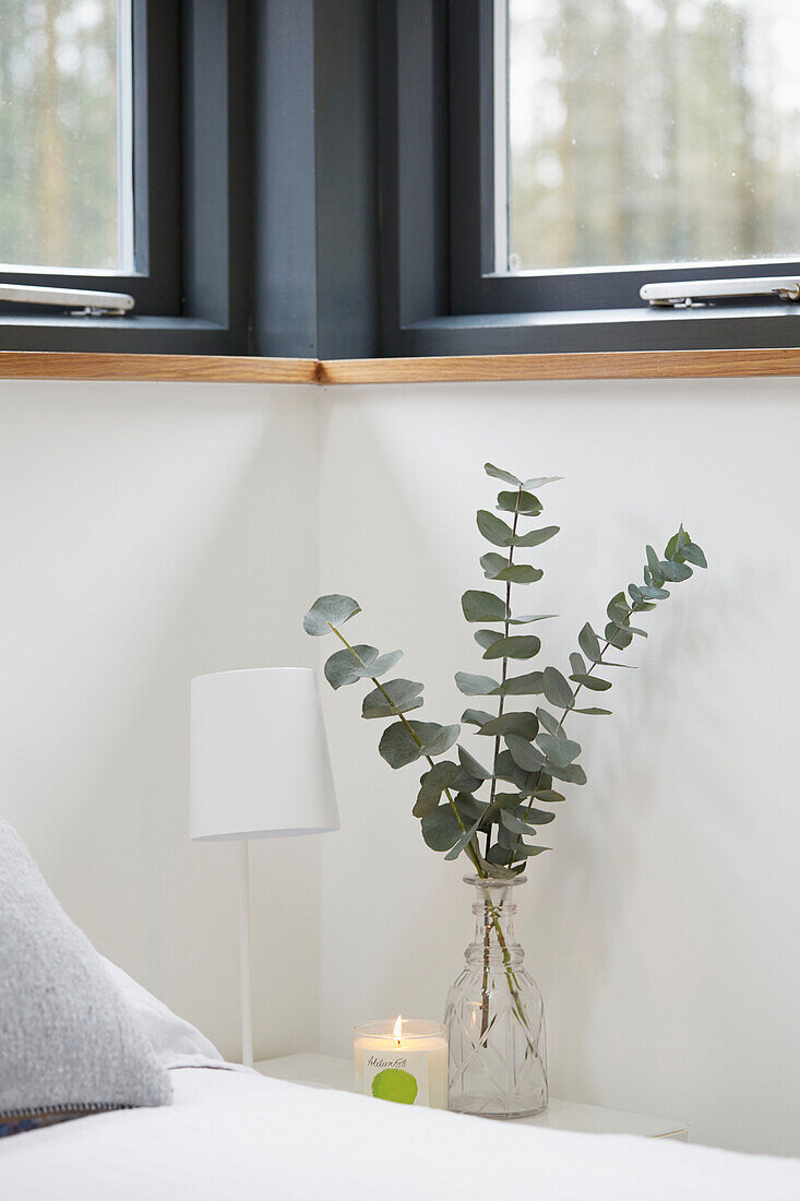 Cut leaves and lit candle at bedside in Devon new build  UK