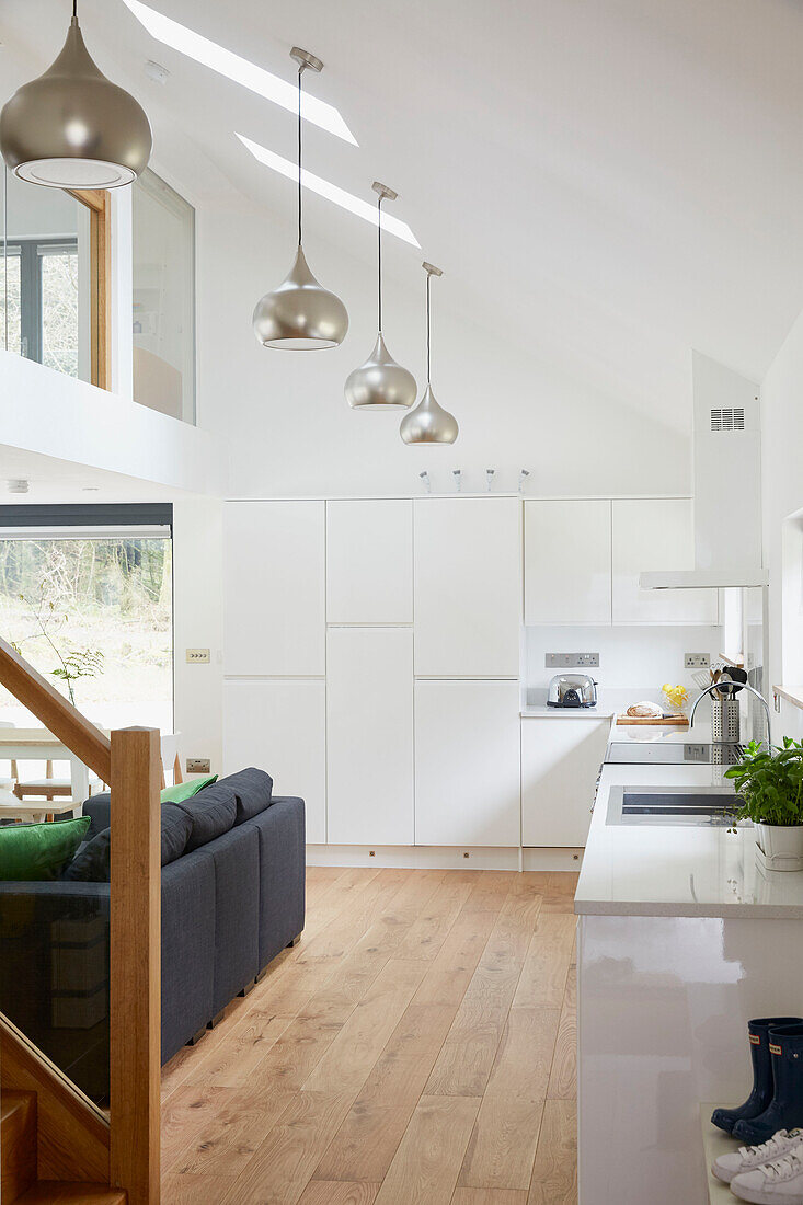 Silberne Pendelleuchten in der offenen Wohnküche eines Neubaus in Devon UK