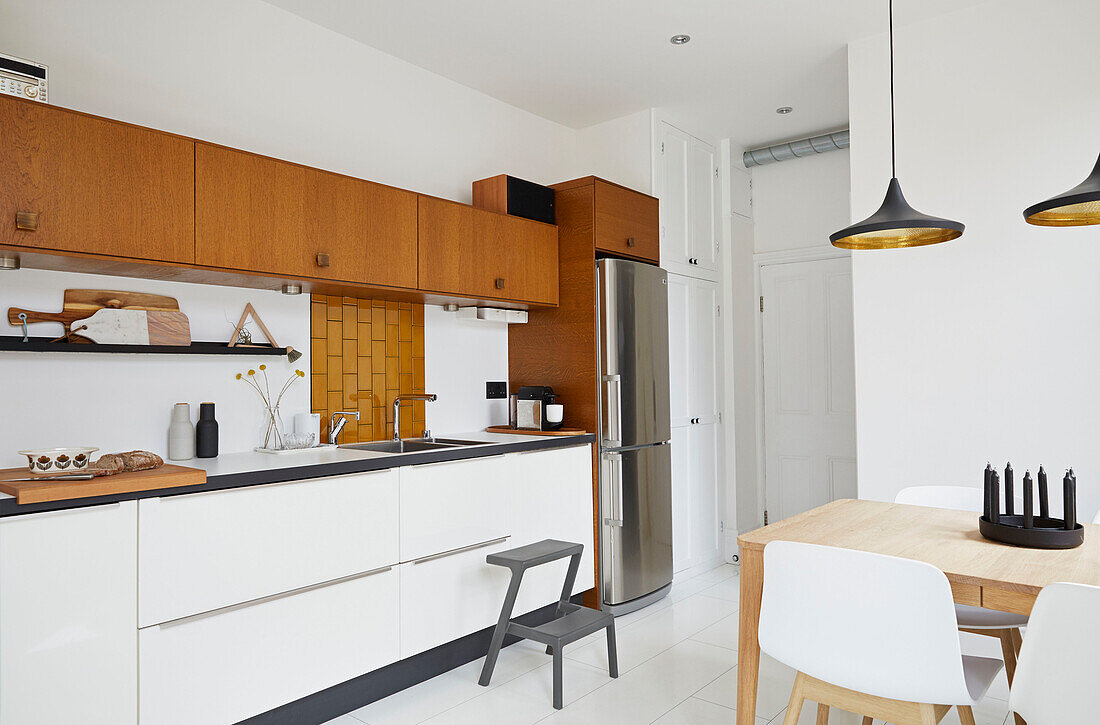 Contemporary kitchen with tiled mustard splashback in modernised Victorian home  Preston  Lancashire  England  UK