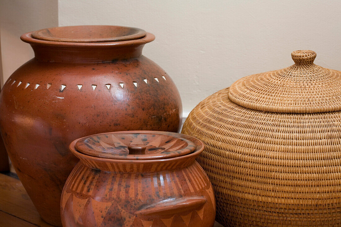 Earthenware pots and natural fibre basket in New Malden home, Surrey, England, UK