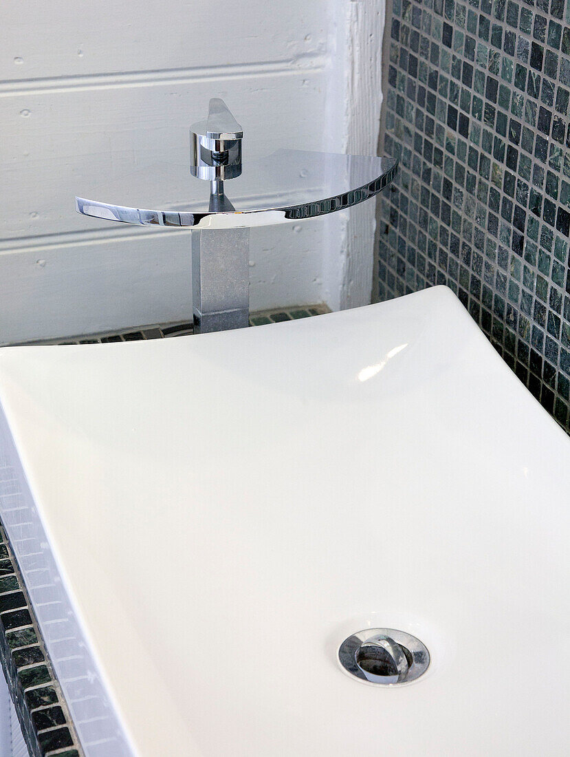 White ceramic basin in grey tiled wet room of watermill conversion 