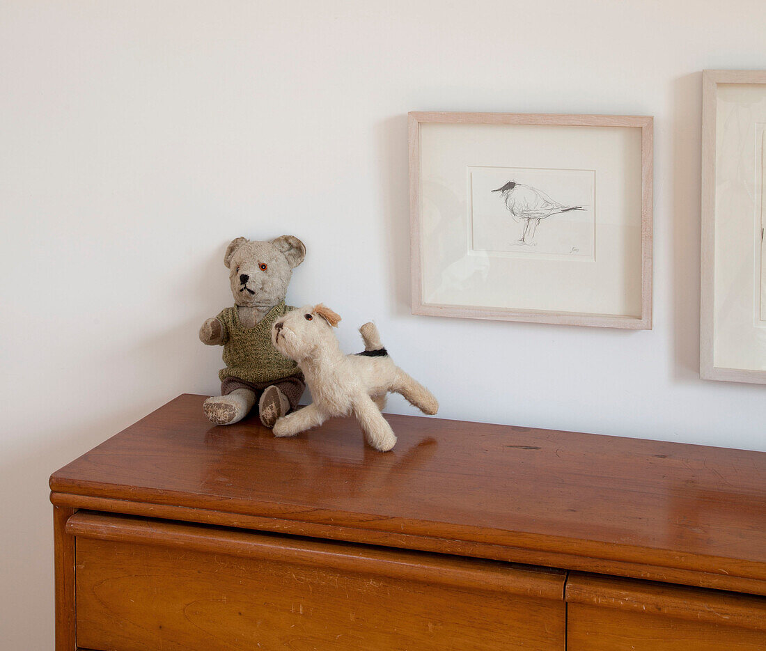 Stofftiere auf hölzernem Sideboard mit gerahmtem Bild eines Vogels in einem Haus in Essex, England