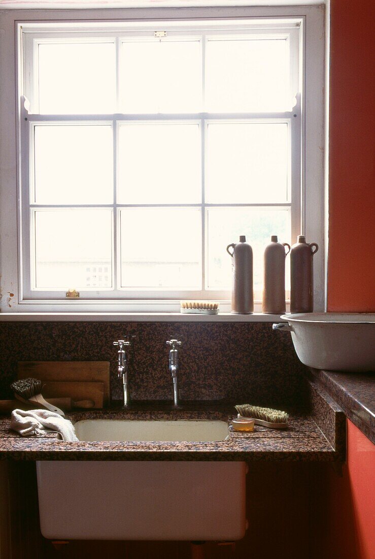 Kitchen sink with granite draining board in utility room by window