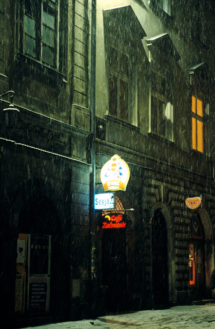 Schnee auf der Straße vor einer Bar bei Nacht