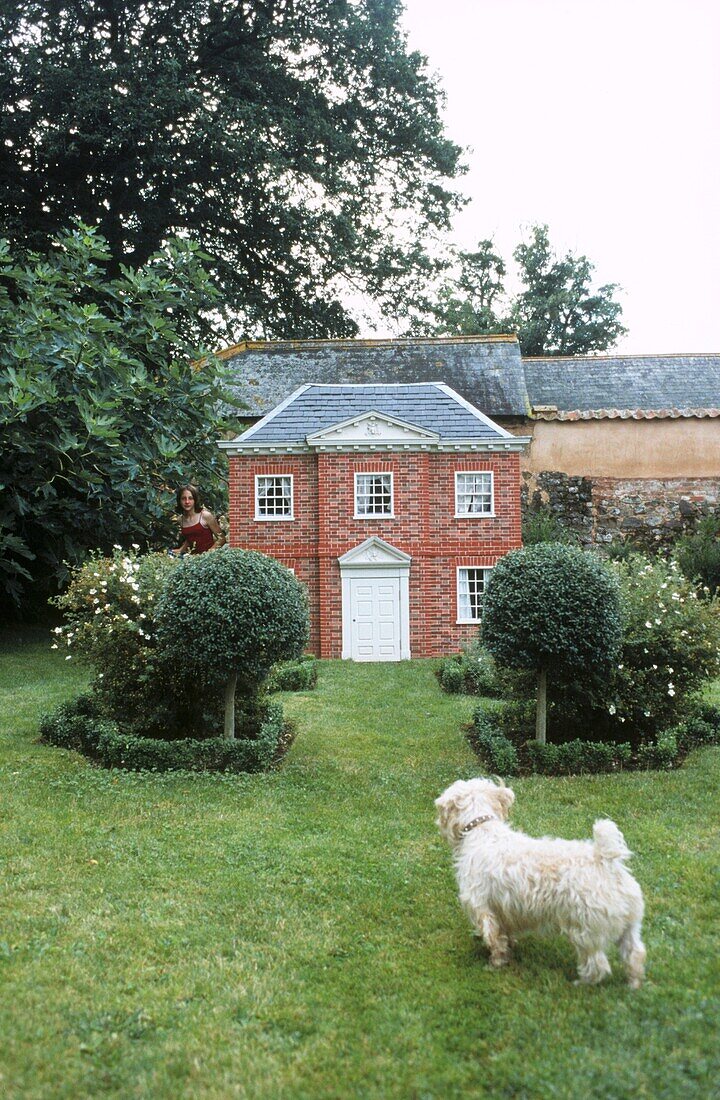 Miniature Georgian house in garden with white Scottie dog