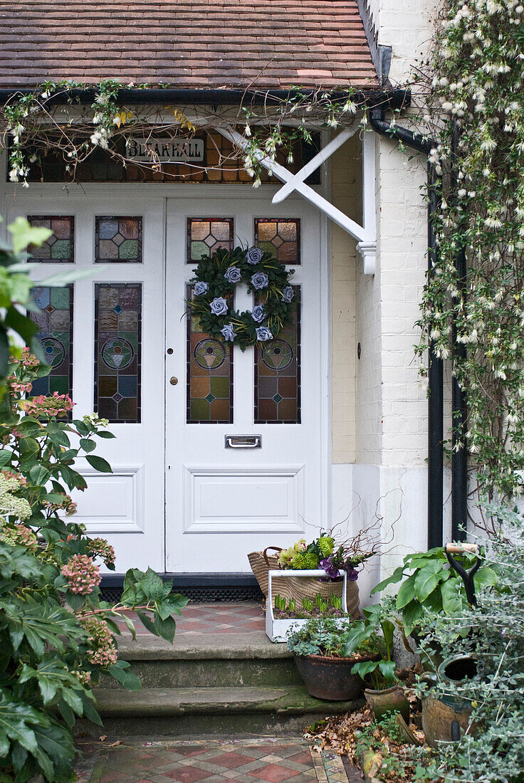 Stained glass front door of porch with trailing plants