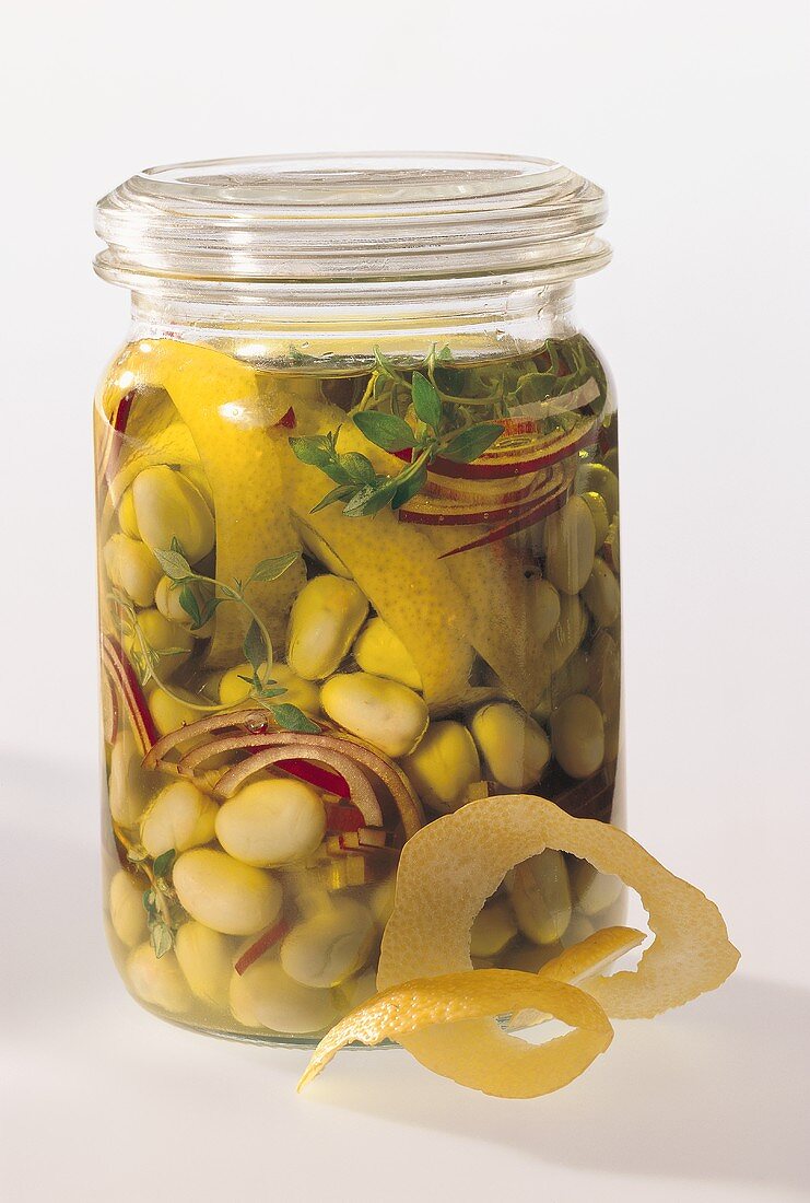 Pickled beans with onions and lemon peel in jar