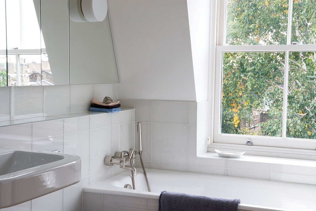 White bathroom and window with mirrored cabinet