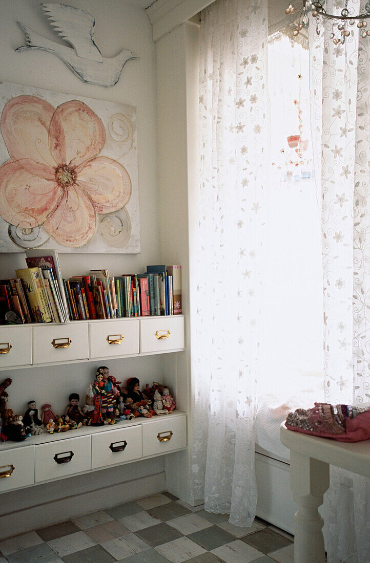 Books and figurines on shelf in bedroom