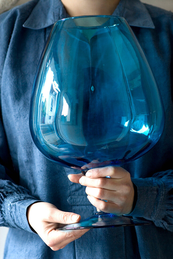 Woman holding blue large glass vase