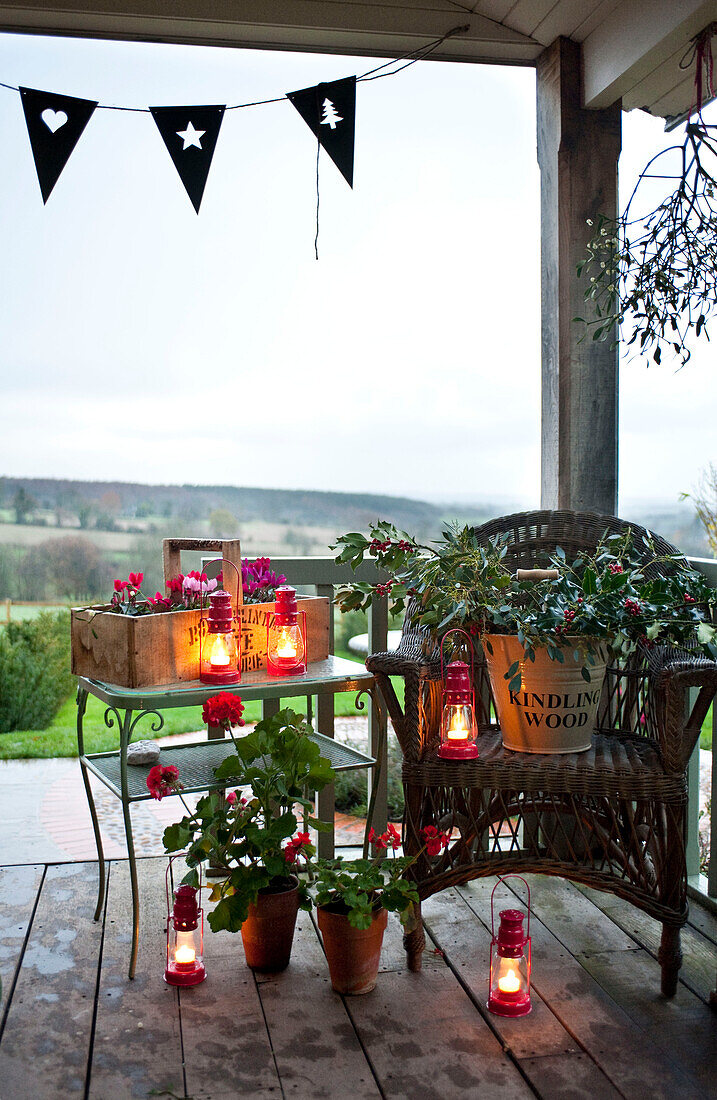 Lit candles and houseplants on decked veranda of Hereford country home