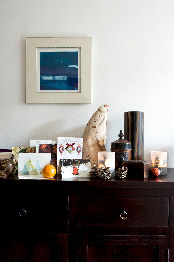 Detail of living room sideboard decorated with ornaments and Christmas cards