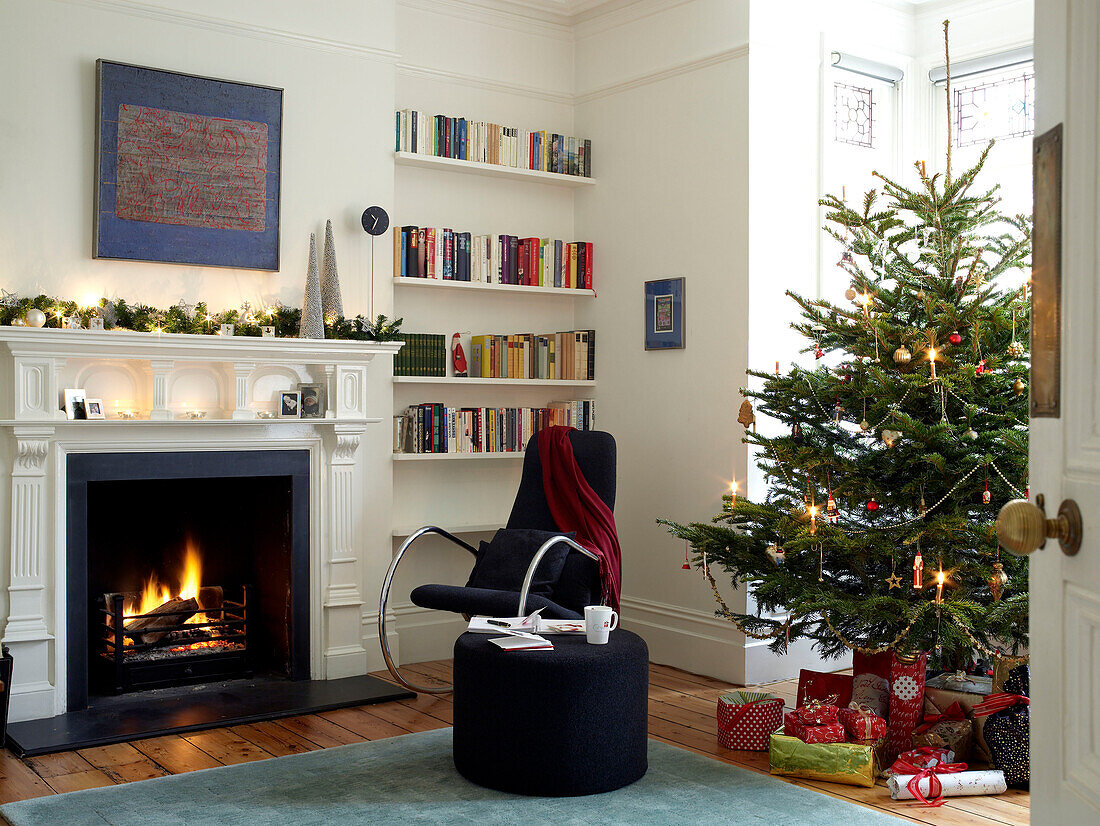 Lit fire in a living room decorated for Christmas