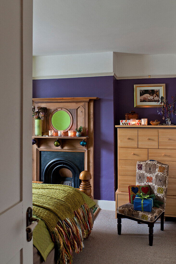 Gift wrapped presents on chair in purple bedroom of London home UK