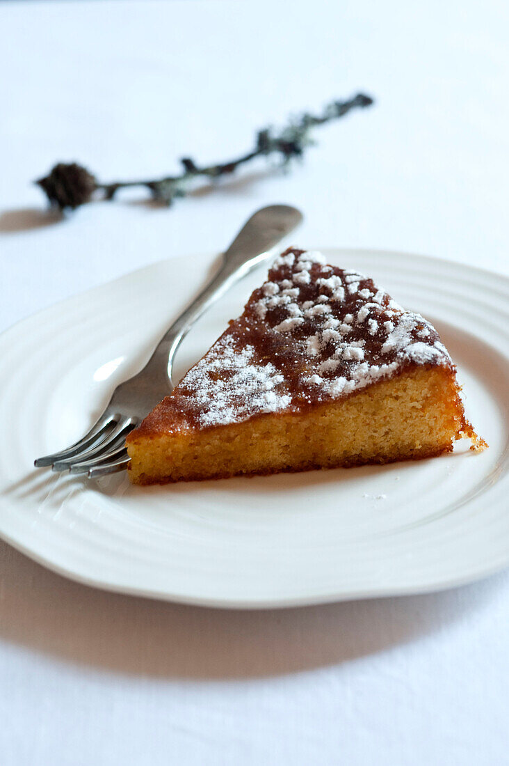 Slice of bakewell tart with dessert fork on plate