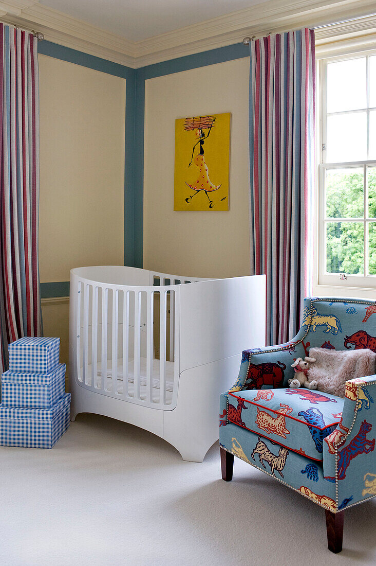 Überprüfte Aufbewahrungsboxen und Kinderbett mit gepolstertem Sessel in einer Ecke des Kinderzimmers in einem Stadthaus in West London, England, UK