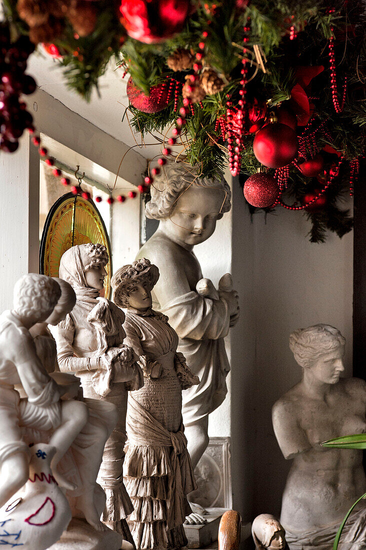 Gipsfiguren und roter Weihnachtsschmuck in einem Haus in Cheltenham, Gloucestershire, England, UK