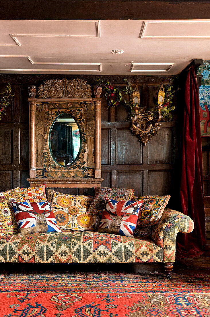 Union-Jack-Kissen auf einem Sofa im getäfelten Salon eines Landhauses in Cheltenham, Gloucestershire, England, UK