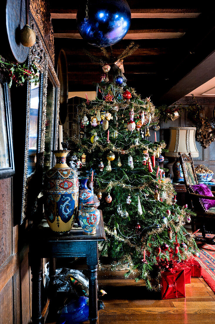 Weihnachtsbaum und blaue Christbaumkugeln mit Vase auf Beistelltisch in Cheltenham Landhaus Gloucestershire England UK