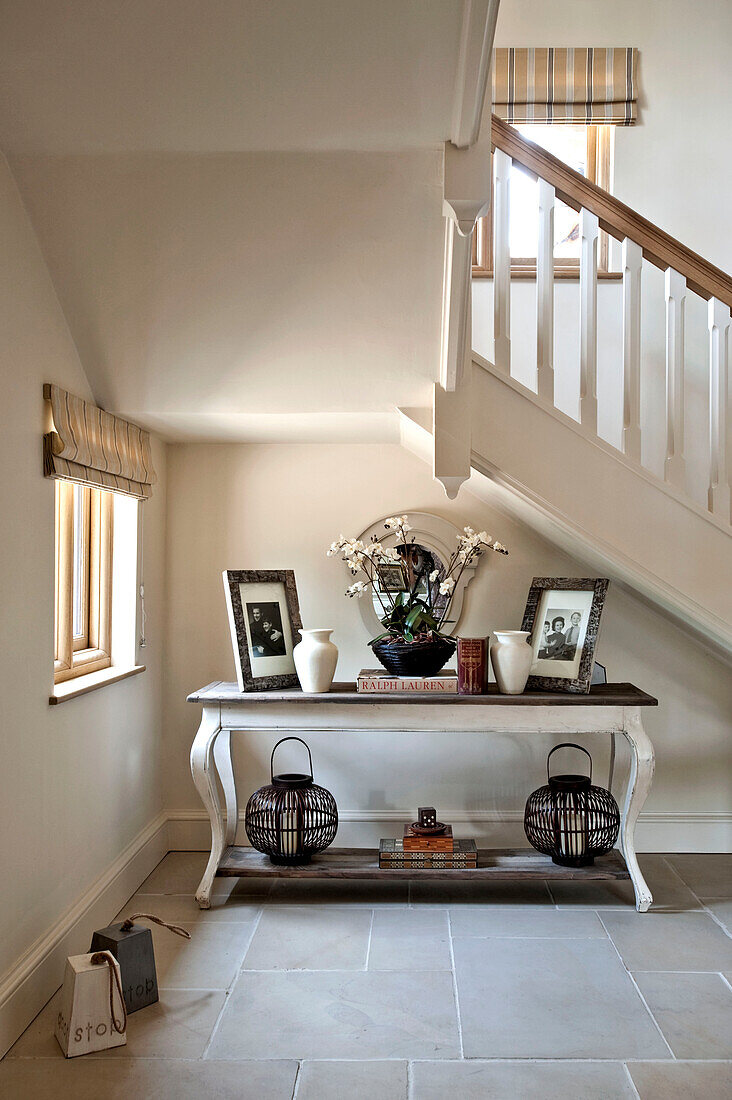 Familienfotos auf einem Beistelltisch am Fenster unterhalb der Treppe in einem Haus in Canterbury, England, Vereinigtes Königreich