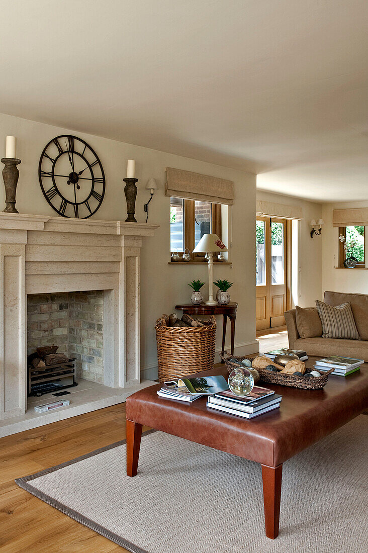 Leather ottoman in front of fireplace with antique roman clock in Canterbury home England UK