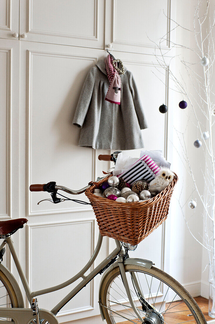 Baubles in bicycle pannier in hallway of Paris apartment, France